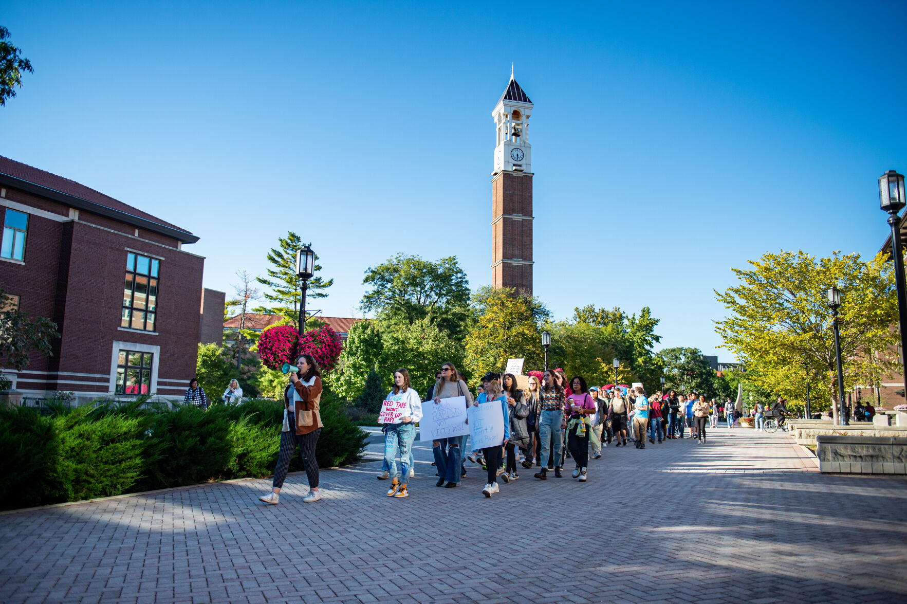 Students rally in support of MeToo movement, Students walk past Bell Tower